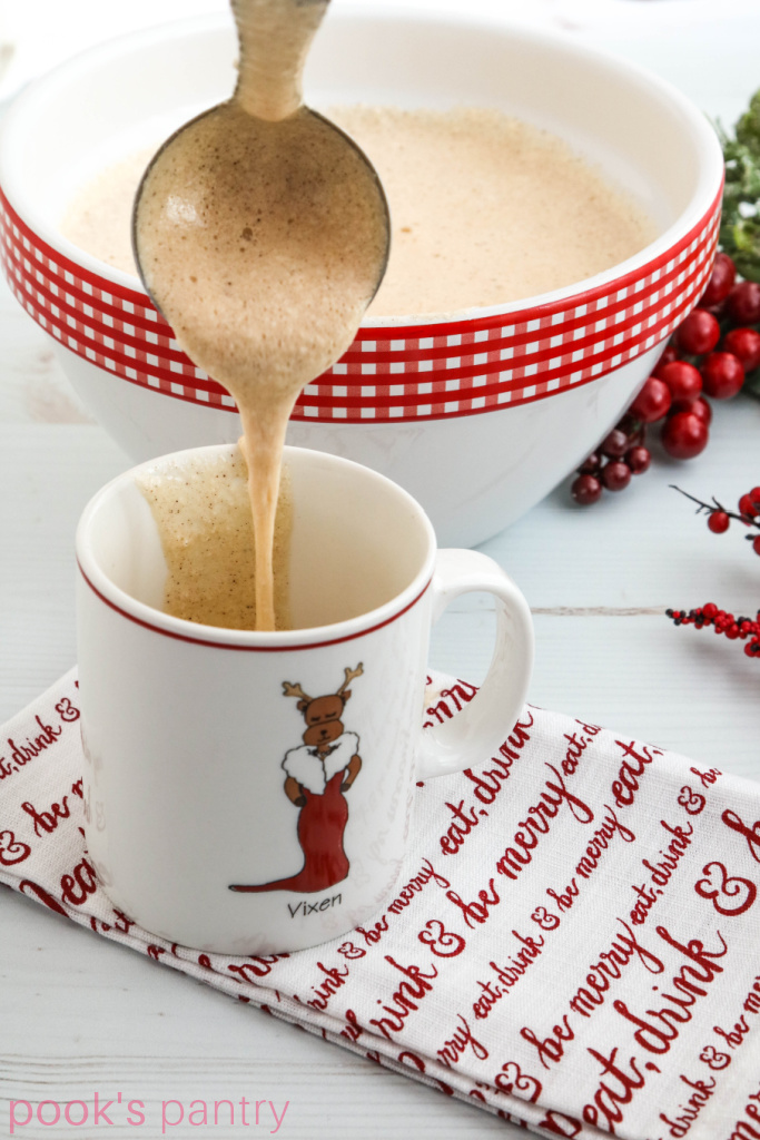 Pouring Tom & Jerry cocktail batter into Christmas mug.