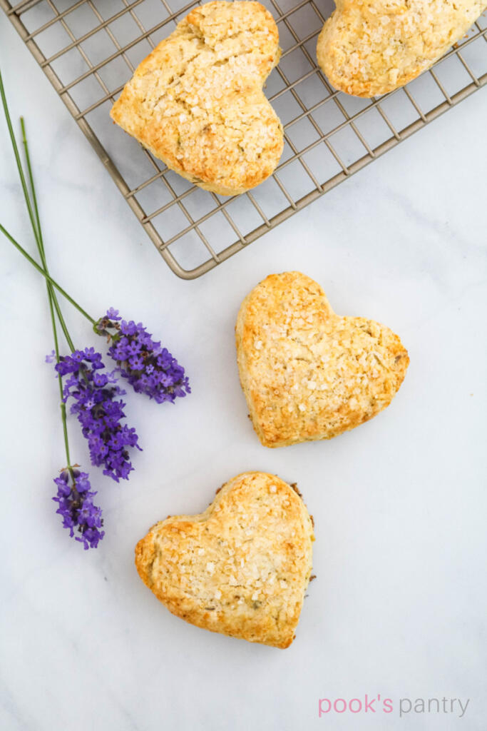 Heart-shaped scones with fresh lavender on white background.