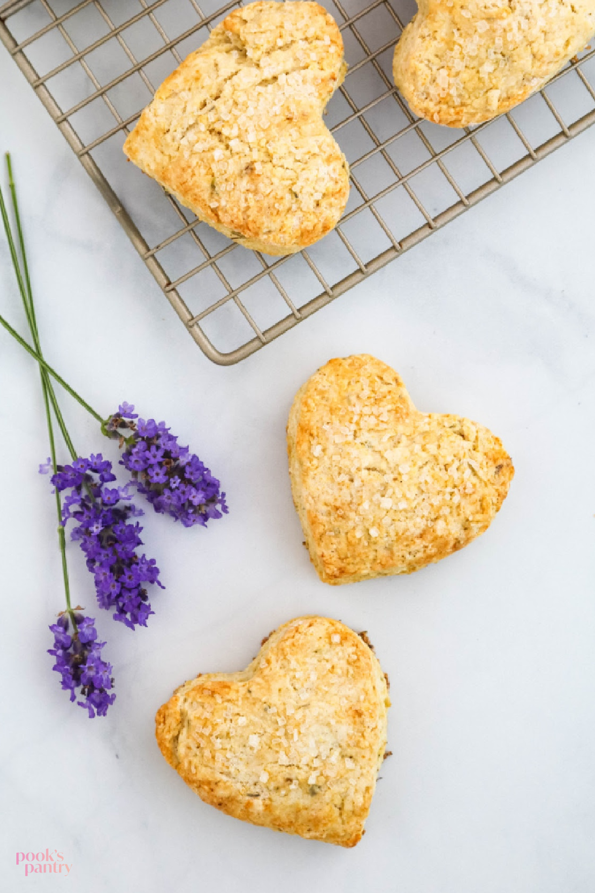 Heart-shaped scones with fresh lavender on white background.