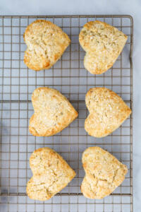 Heart-shaped scones cooling on wire rack.