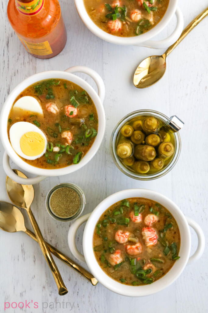 Langostino gumbo with gold spoons.