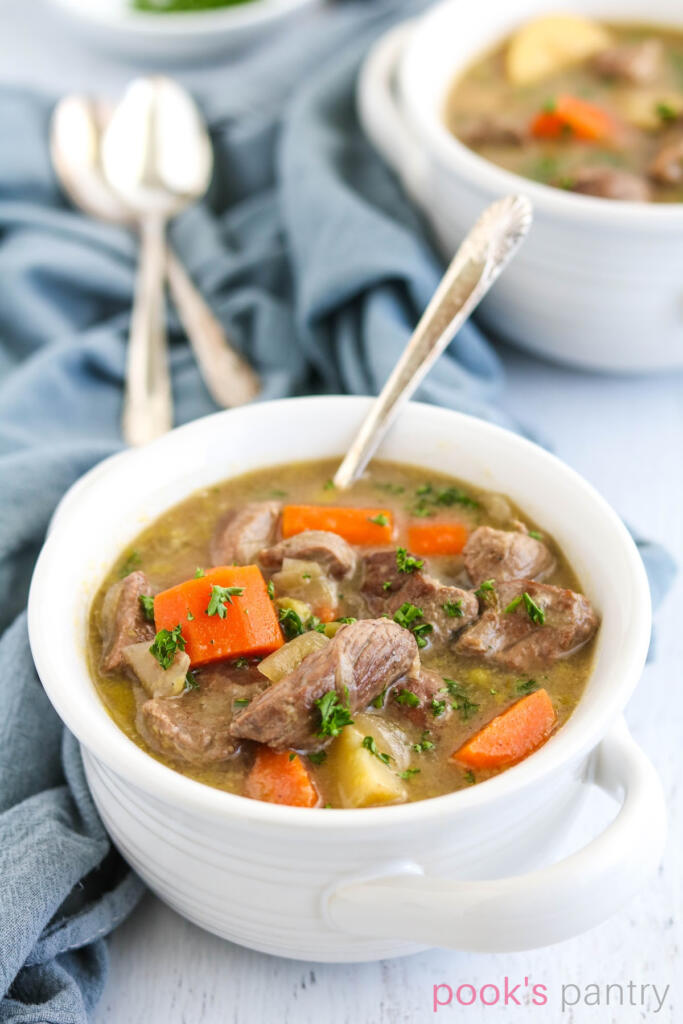 Irish lamb stew recipe with vegetables in white bowls.