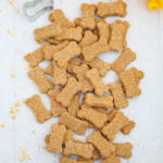 Peanut butter banana dog treats on a white background with a yellow dish towel.