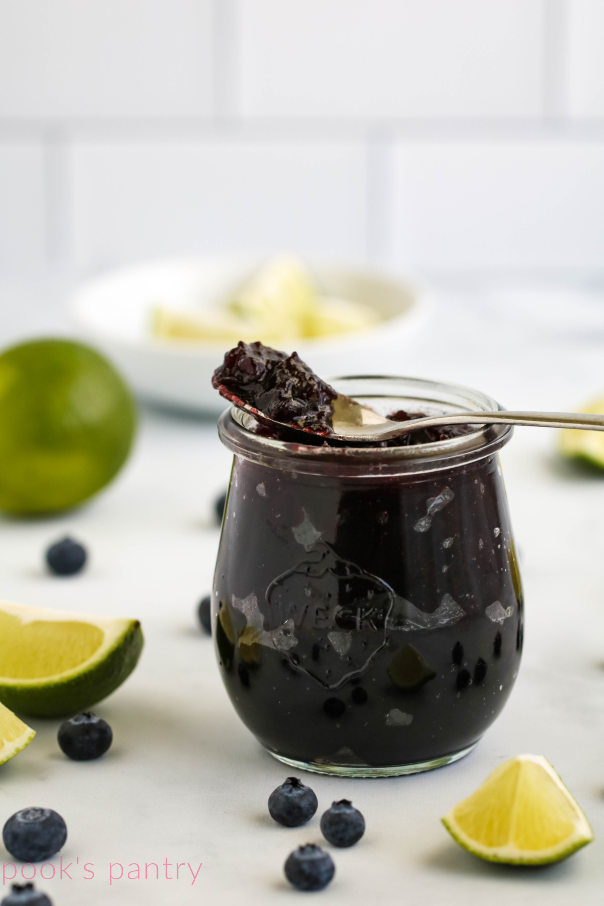 Jam with blueberries and limes in jar.