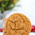 Ginger molasses cookies in front of Christmas decorations on a white background.
