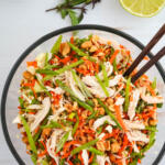 Vietnamese chicken salad with cabbage and chili lime vinaigrette in a glass bowl.
