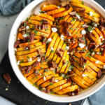 Roasted Honeynut squash in a shallow white baking dish.