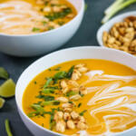 Hubbard squash soup recipe with coconut milk topped with herbs and pumpkin seeds.