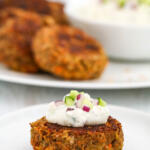 Crispy lentil patties with feta yogurt dip on small white plate.