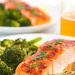 Honey chipotle salmon on a small white plate with roasted broccoli.