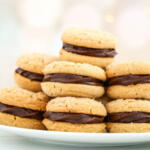 Peanut butter sandwich cookies on a white plate.
