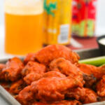 Baked chicken wings with buffalo sauce on sheet pan.