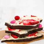 Pieces of Valentines chocolate bark stacked on top of each other on a white background.