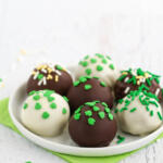 Irish cream whiskey balls on small white plate with green napkin underneath.