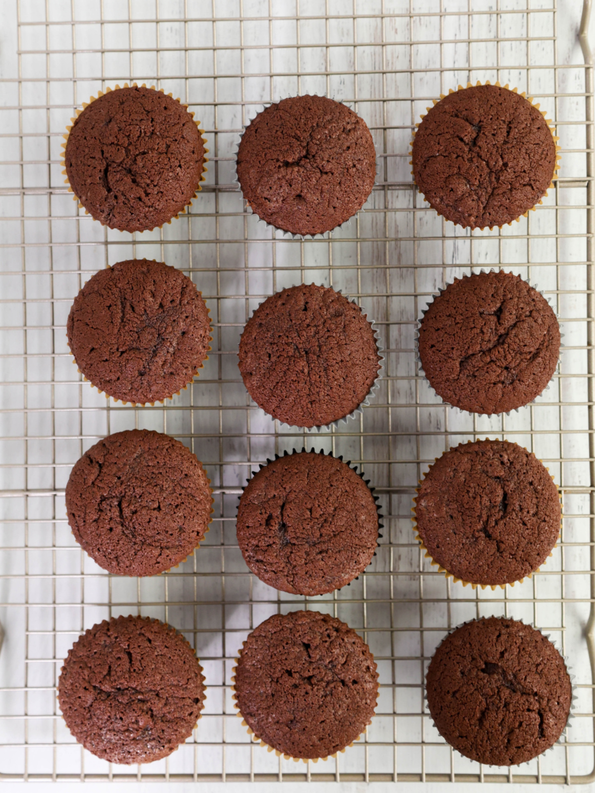 Baked devil's food cupcakes on a cooling rack.