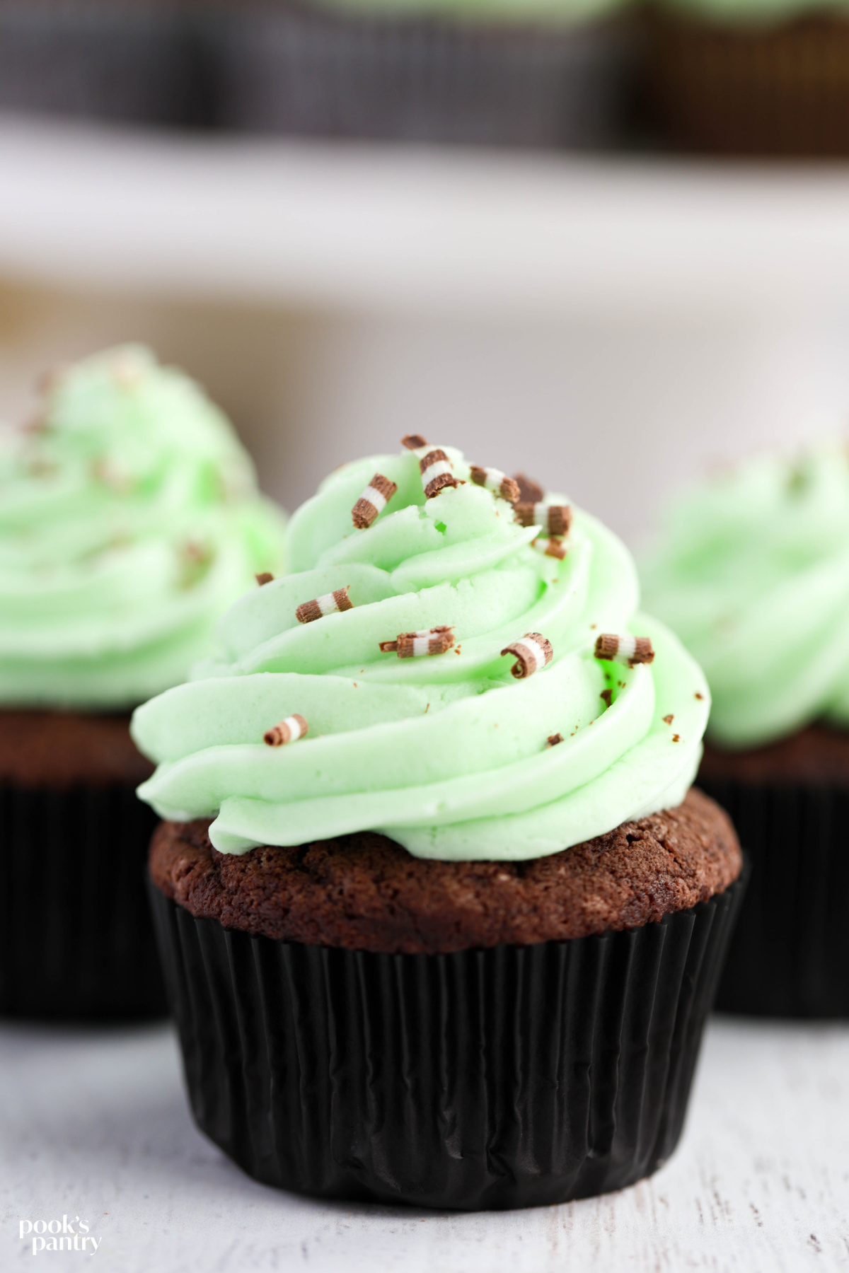 Creme de menthe buttercream on devil's food cupcakes with chocolate curls.