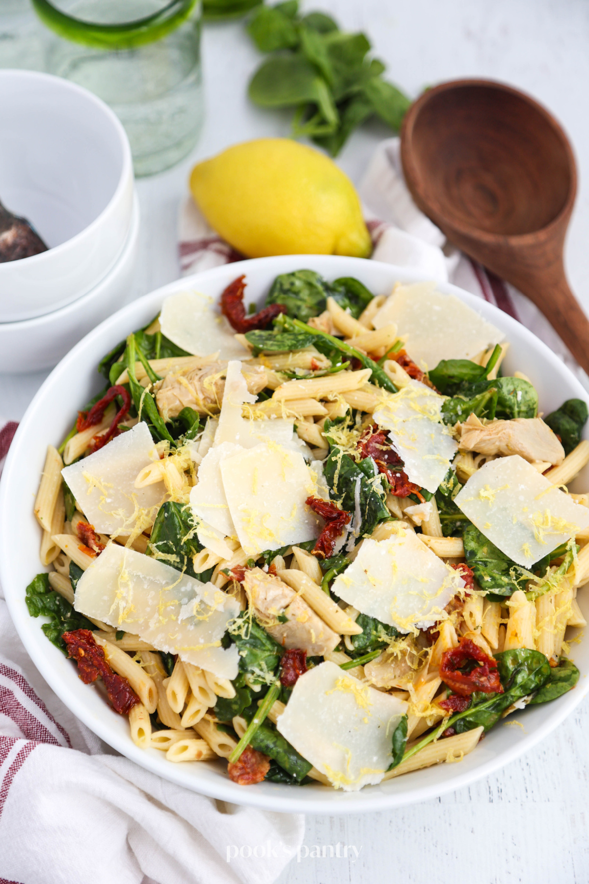Pasta with lemony sauce and Parmesan cheese in a white bowl.