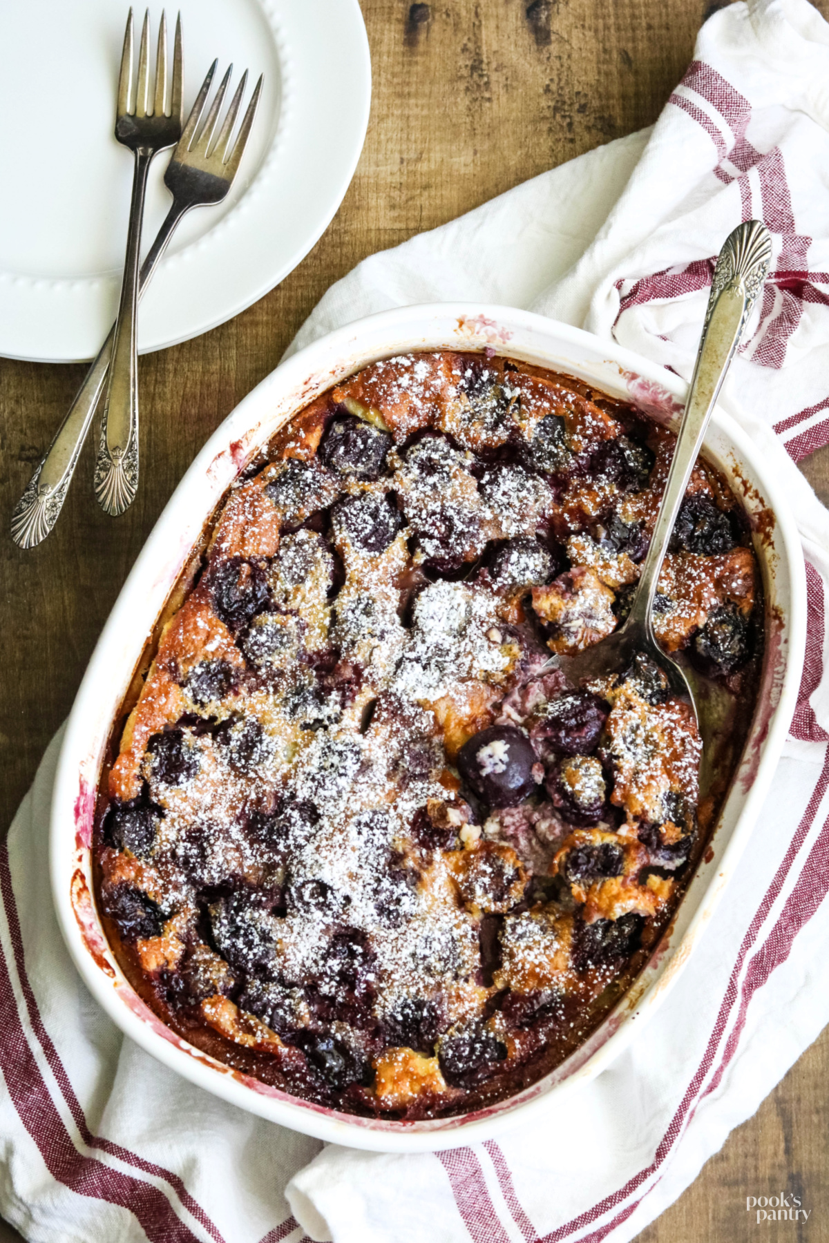 Fresh cherry clafoutis in a white baking dish.