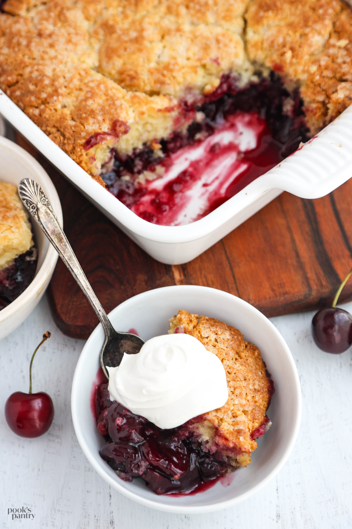 A close up photo showing the texture of the cherry cobbler filling and topping in a small white bowl.