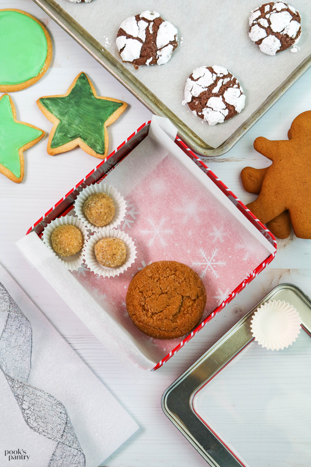 Cookies ready to be packed into a metal tin, surrounded by packing material and ribbon.
