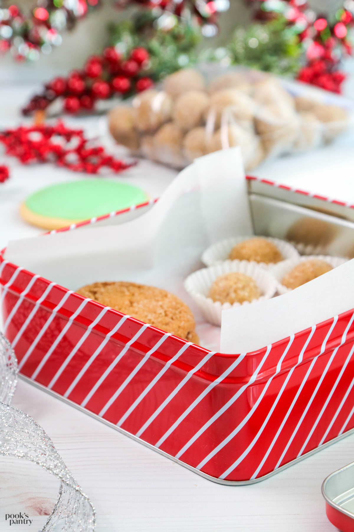 Packing a cookie tin with parchment paper and packaged cookies.