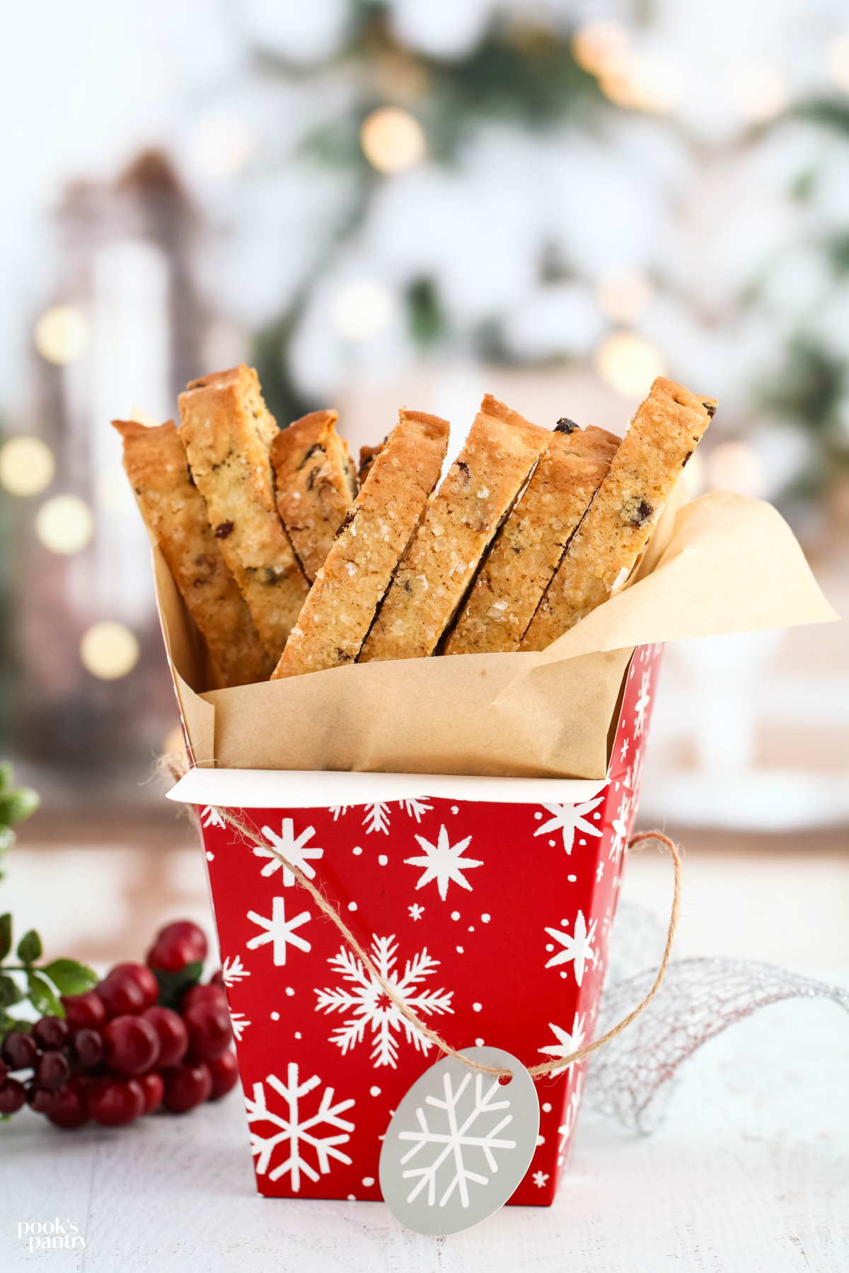 Almond biscotti in a paper cookie box with parchment paper.