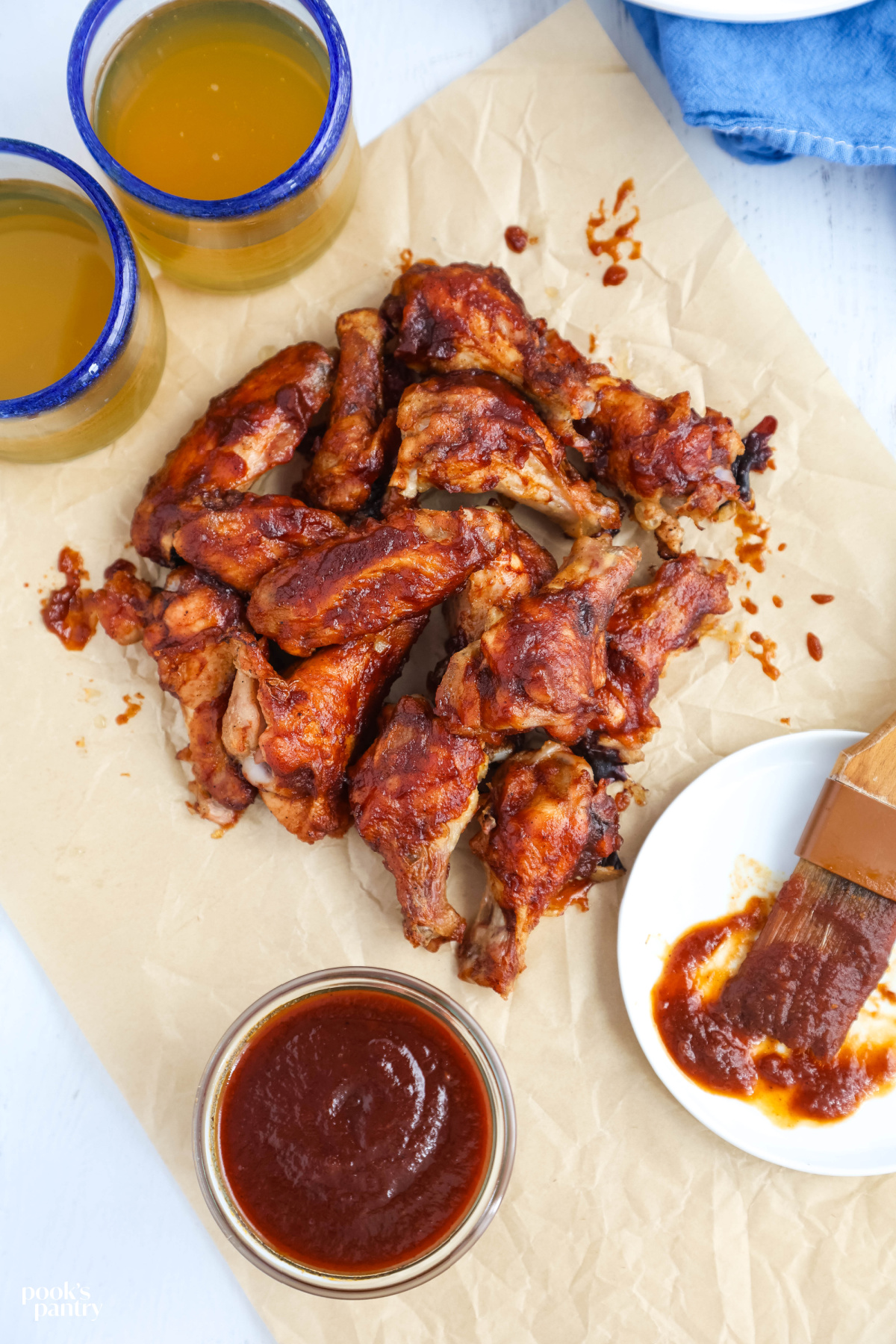 Chicken wings with maple BBQ sauce on brown parchment paper.