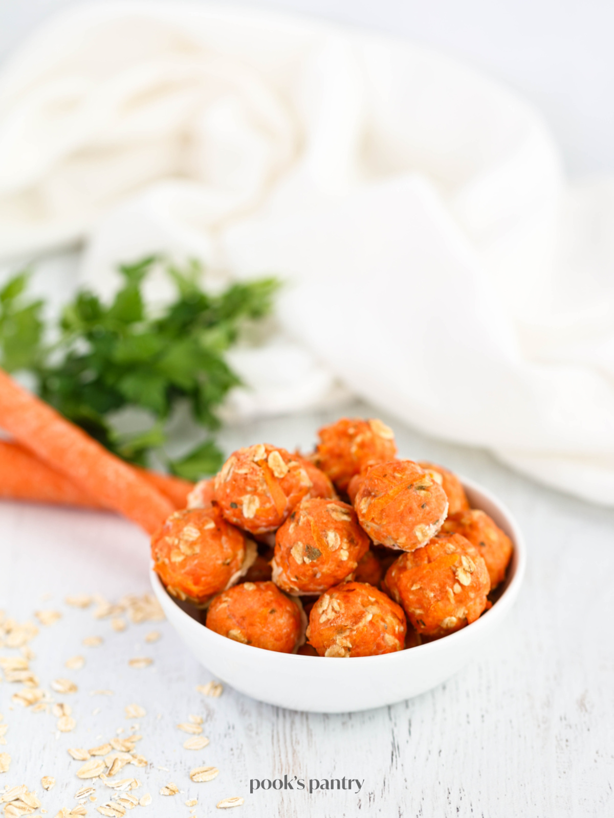 Homemade salmon meatballs for dogs stacked inside of a small bowl.