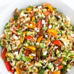 Tri-color Mediterranean orzo pasta salad in white bowl.