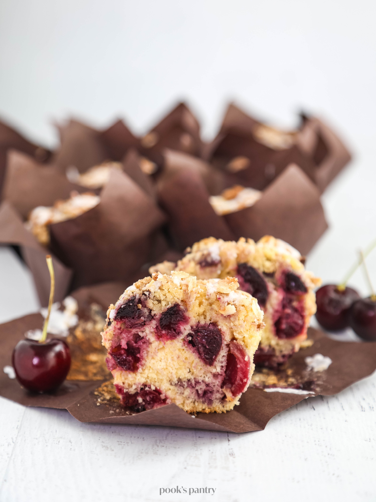 Cut open muffin showing the even distribution of cherries from top to bottom.