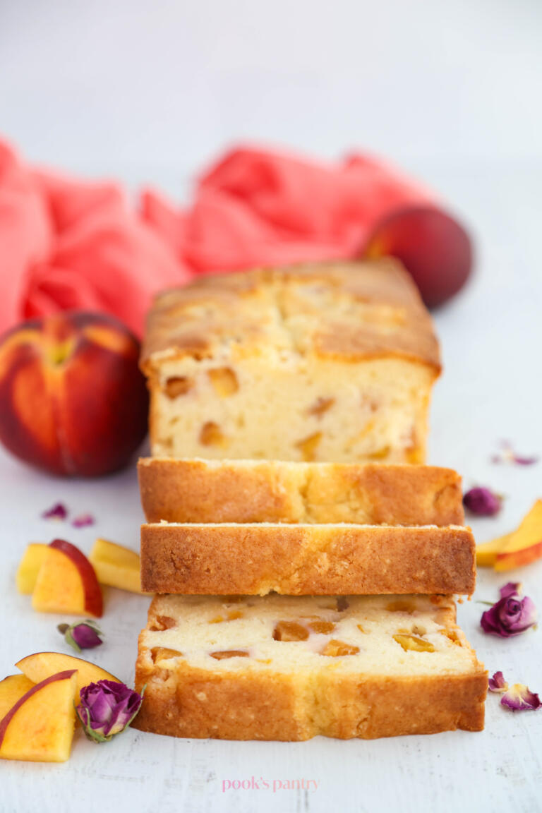 Peach pound cake slices, with slices of fresh peaches on the side of the cake.