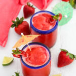 Strawberry daiquiris with colorful paper drink umbrellas.