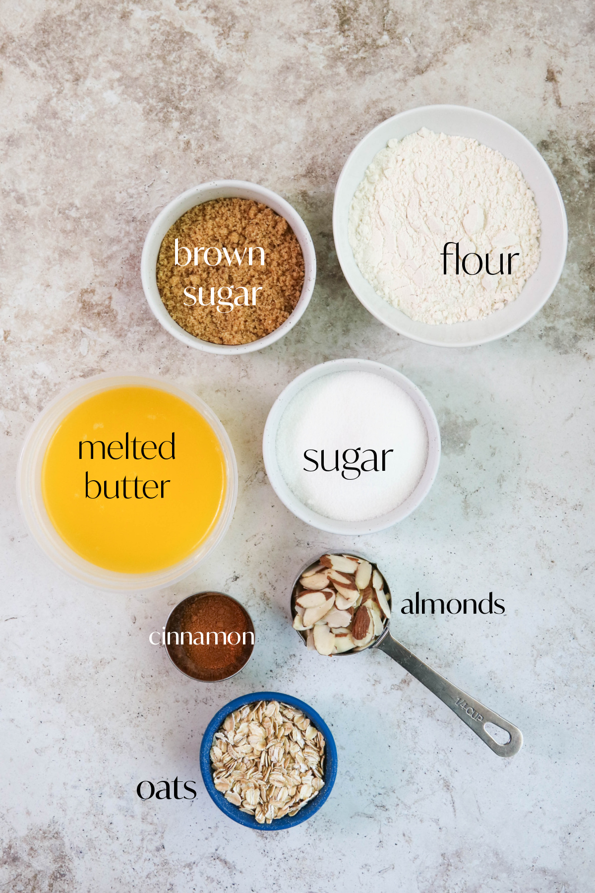 Ingredients for cinnamon almonds streusel on a tan background.