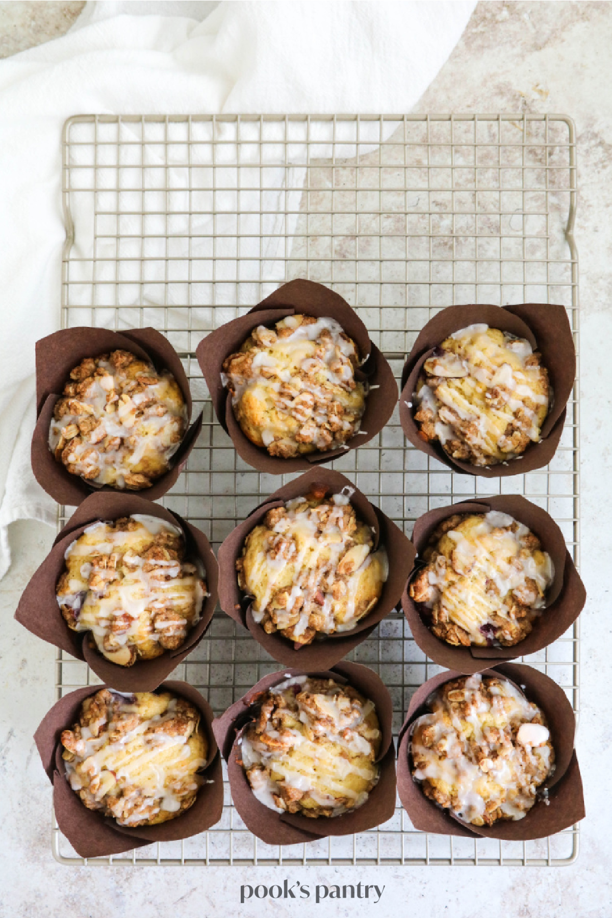 Cherry muffins with crumble topping on a metal cooling rack.