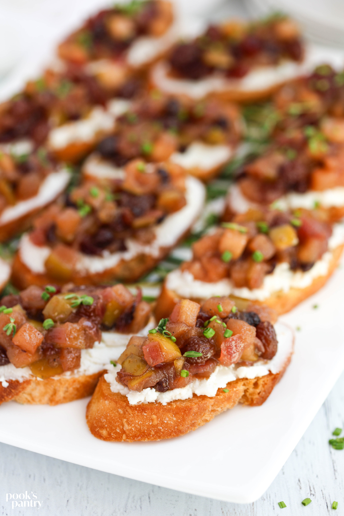 Close up of a platter of bruschetta, showing the texture of the chutney.