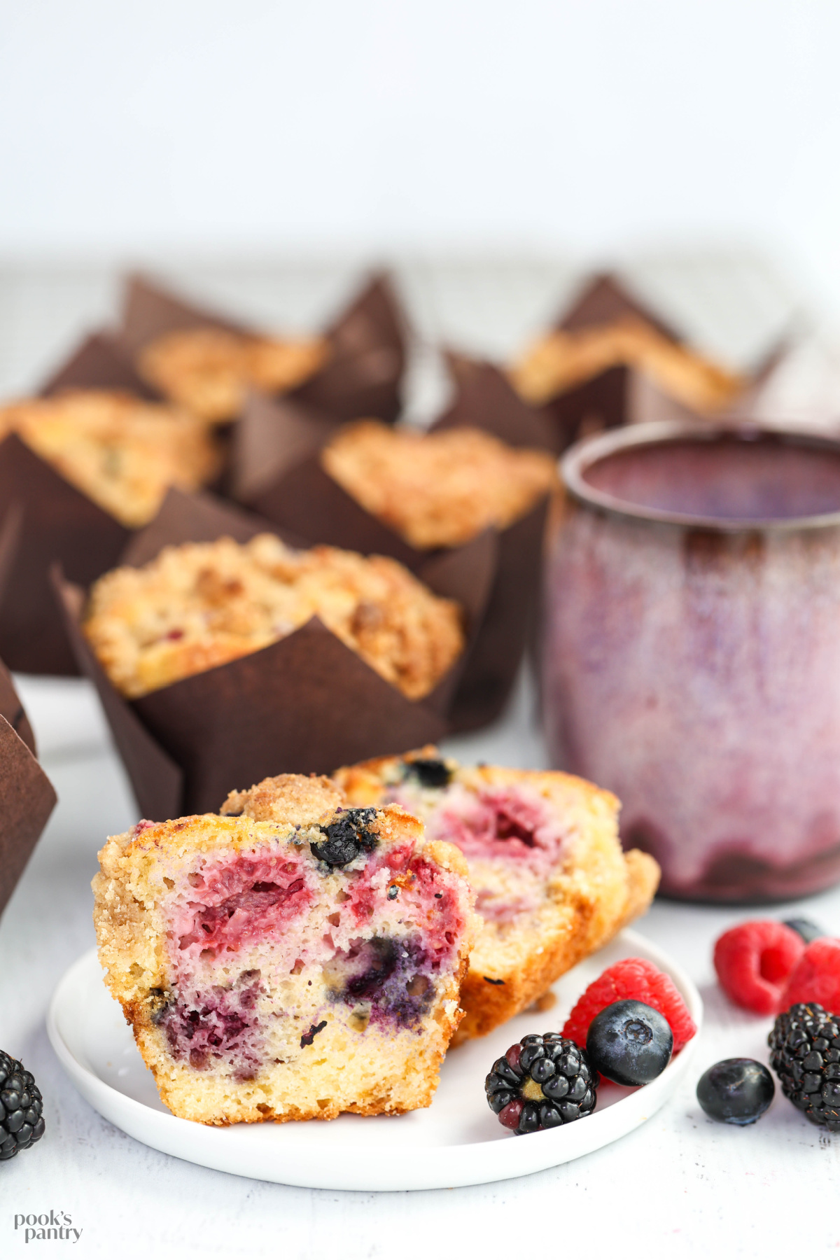 Close up photo of a cut open muffin, showing the evenly distributed berries inside.