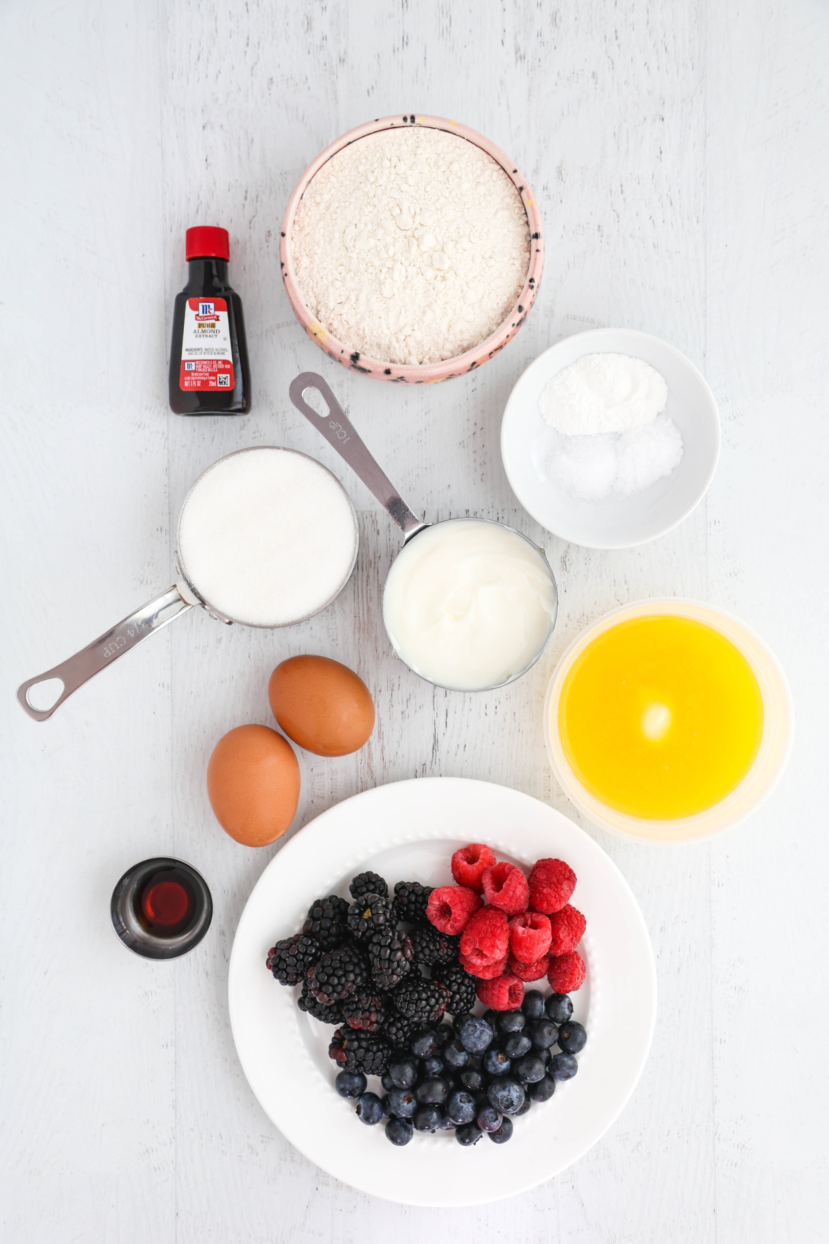 Overhead view of bumbleberry muffins on a white background.