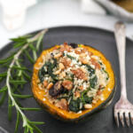 Sausage stuffed acorn squash on plate.