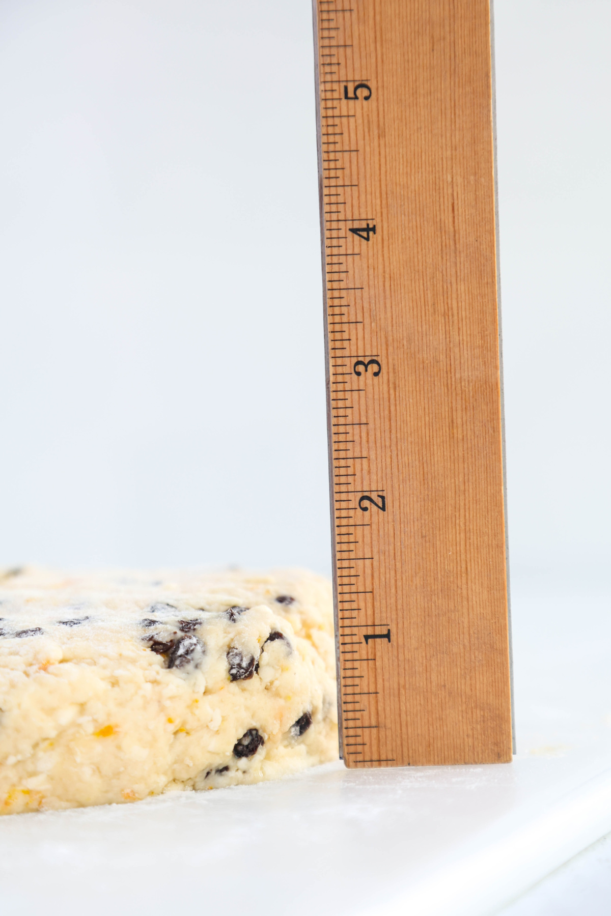 Measuring the scone dough to show how tall it is.