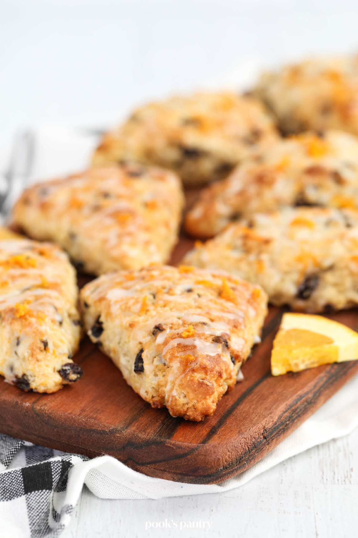 Close up photo of glazed scones on board, showing glaze and orange zest.
