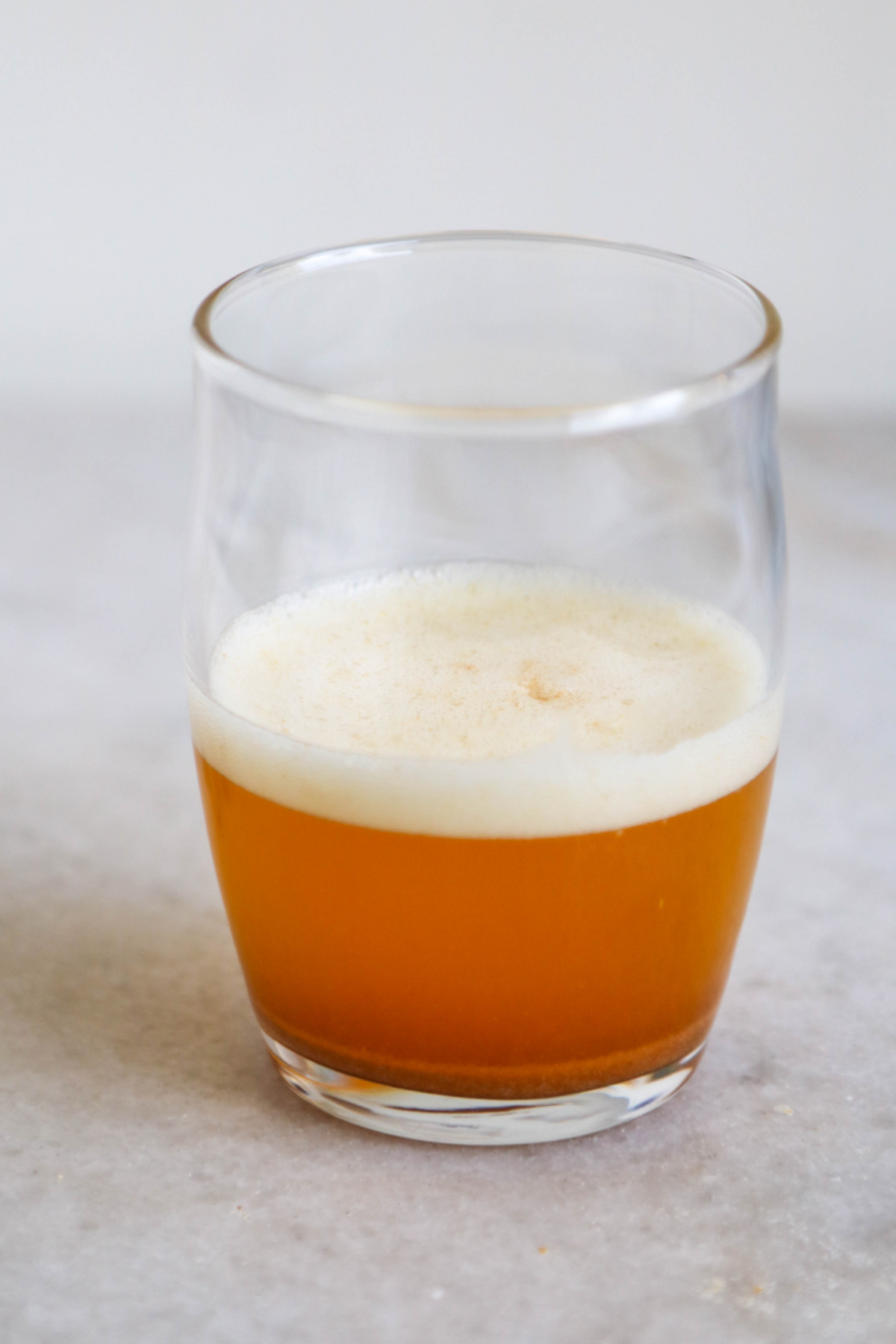 Brown butter, with foam on top, in a small clear glass, showing the ideal color.