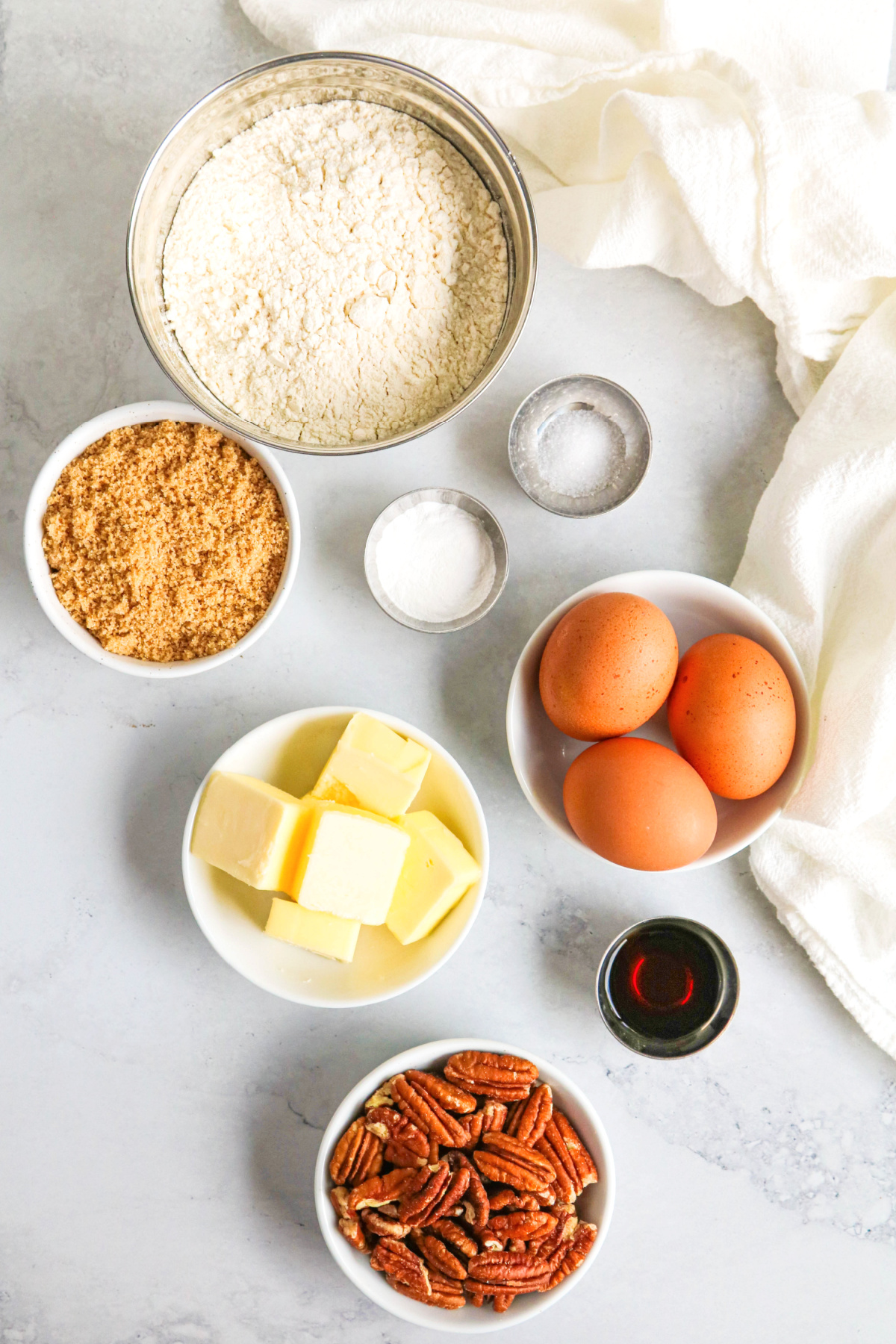 Ingredients for butter pecan biscotti recipe on a light gray background.