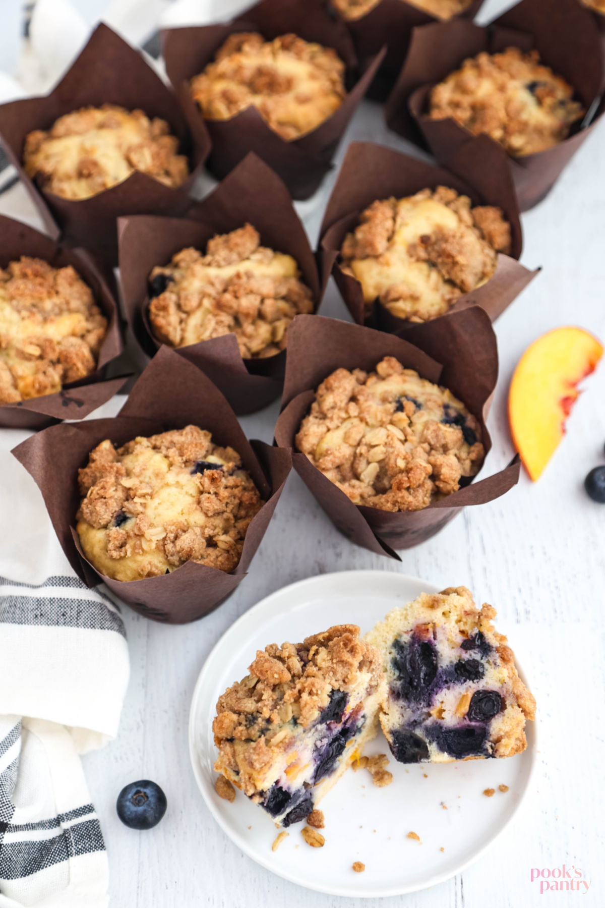 A cut open muffin on a small plate showing the fruit-packed inside.